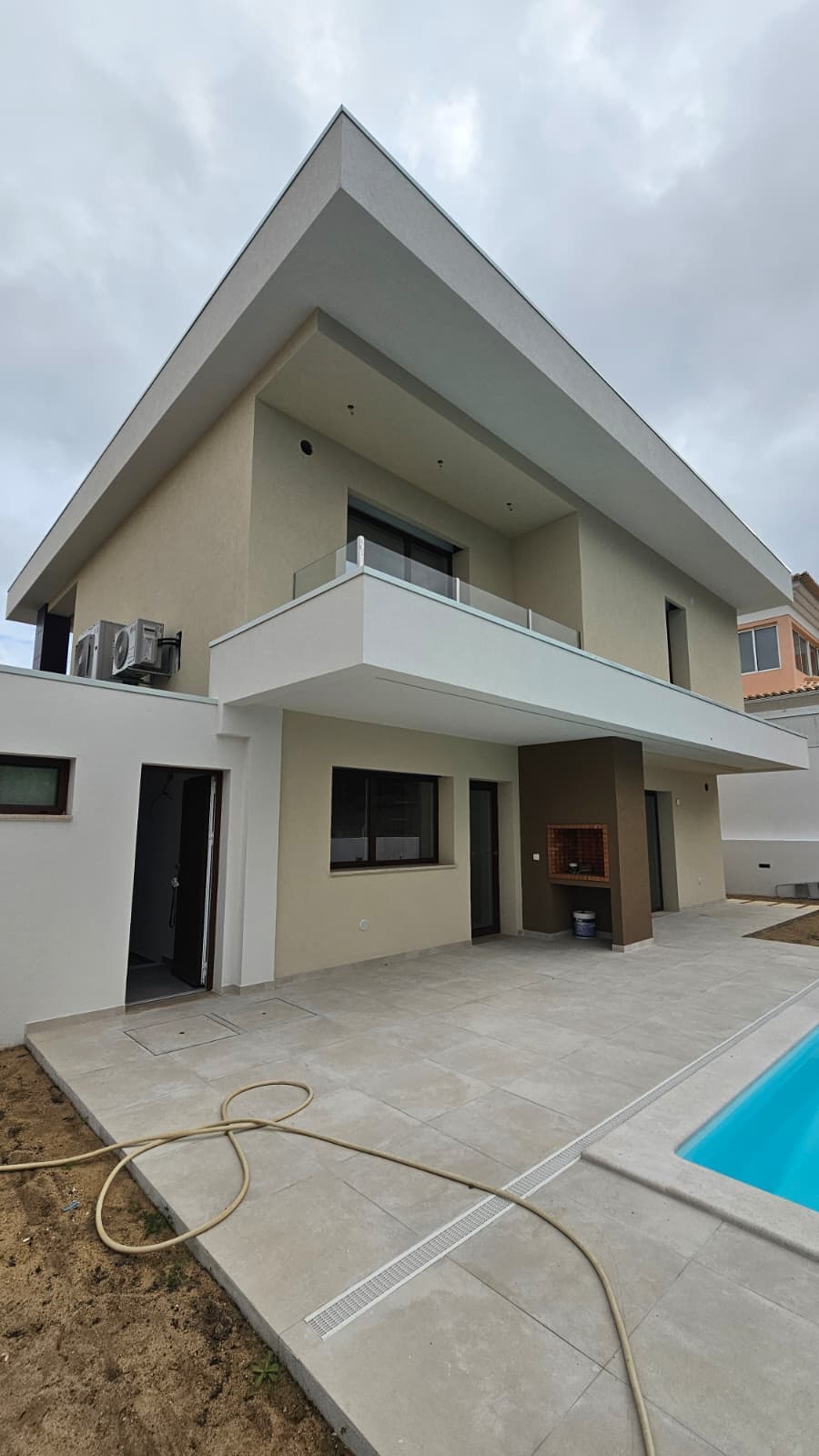 Parte traseira de uma moradia concluída com terraço e piscina