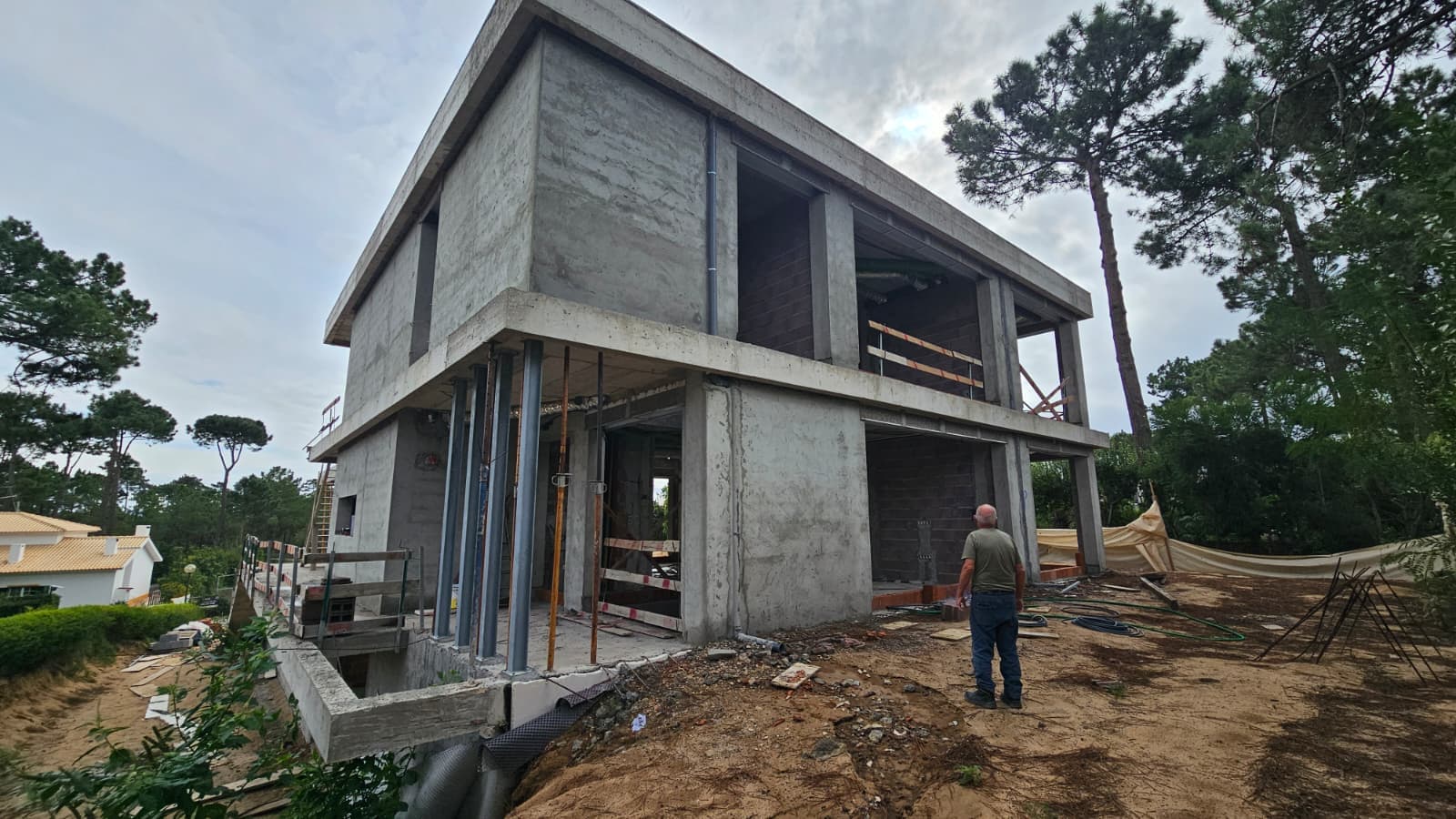 Moradia em construção com estrutura exposta e contexto real de obra